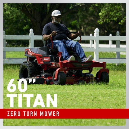 Man operating a Toro 60" Titan zero turn mower in a grassy area with a white fence and trees in the background.