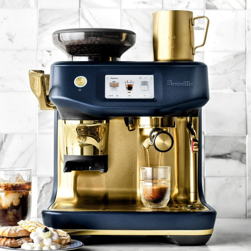 Breville coffee machine with a glass of coffee on a marble countertop