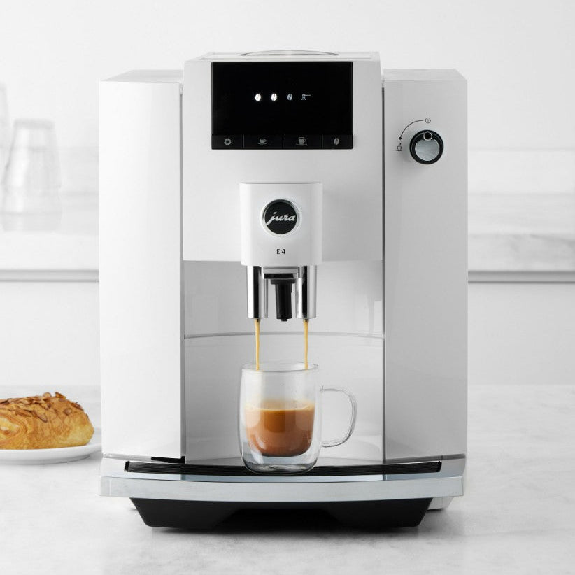 Modern coffee machine dispensing a cup of coffee on a white background