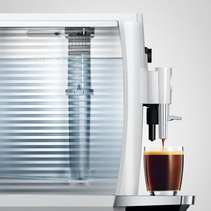 Coffee machine dispensing coffee into a glass on a white background
