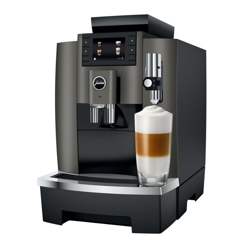 Black coffee machine with a glass of layered coffee on a white background