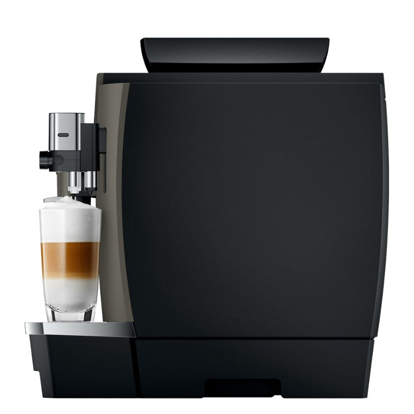 Black coffee machine with a glass of layered coffee on a white background