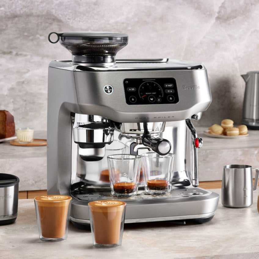Breville coffee machine with espresso shots in front on a kitchen counter.