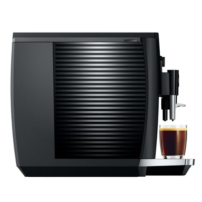 Black coffee machine with a glass of coffee on a white background