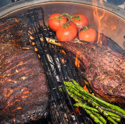 Grilled steak, tomatoes, and asparagus on a barbecue grill with flames.