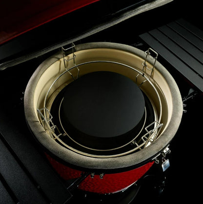 Close-up of a red and black drum with a circular metallic object inside