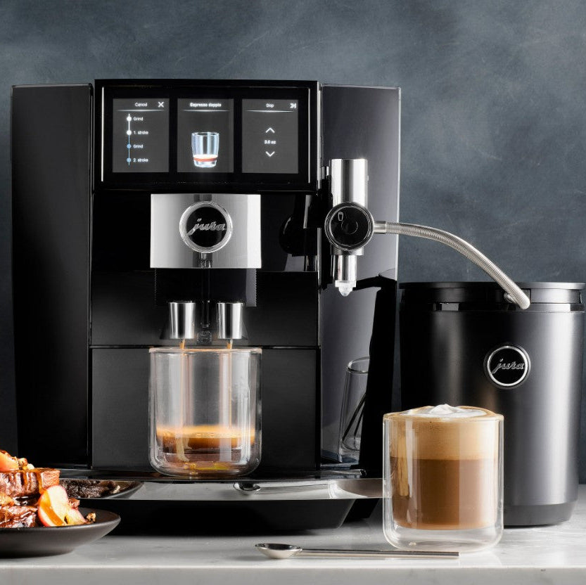 Modern coffee machine with a glass of coffee and a container on a gray background