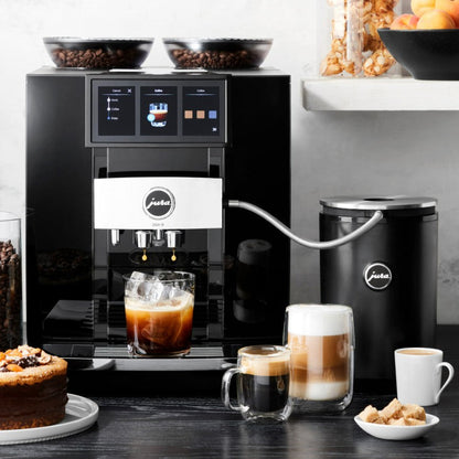 Jura coffee machine with various coffee beverages and ingredients on a counter.