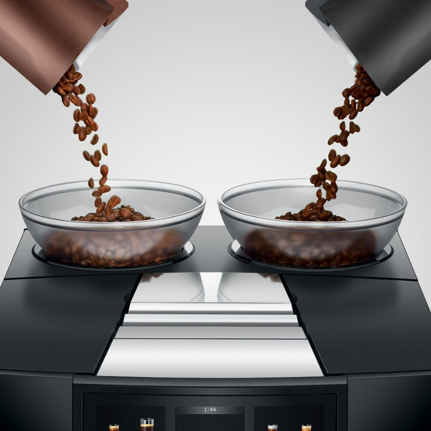 Two glass bowls filled with coffee beans on a modern kitchen countertop.
