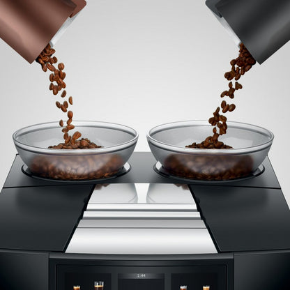 Two glass bowls filled with coffee beans on a modern kitchen countertop.