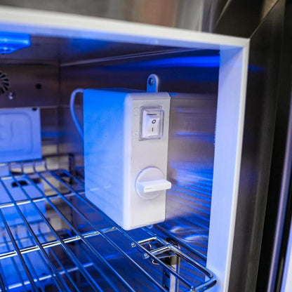 Close-up of a kitchen appliance with a control panel and blue light