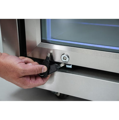 Person using a key to unlock a stainless steel appliance.